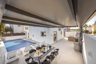 a patio with a table and chairs next to a swimming pool at Villa Antonieta in Ayia Napa