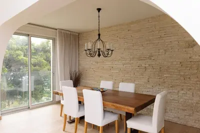 a dining room with a wooden table and white chairs at 3BR Beachfront Gem in Limassol in Limassol