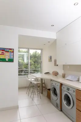 a kitchen with a washing machine and a table at 3BR Beachfront Gem in Limassol in Limassol