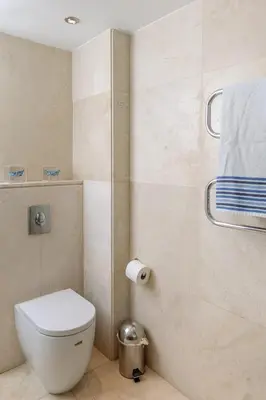 a bathroom with a white toilet and a shower at 3BR Beachfront Gem in Limassol in Limassol