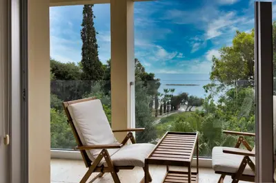 two chairs sitting on a porch with a view of the ocean at 3BR Beachfront Gem in Limassol in Limassol