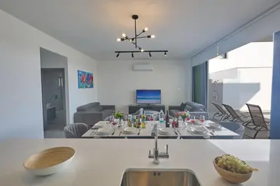 a kitchen and living room with a table and a sink at Protaras Aqua Pearl Villa AQ12 in Paralimni