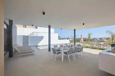 a dining room with a table and chairs on a patio at Protaras Aqua Pearl Villa AQ12 in Paralimni
