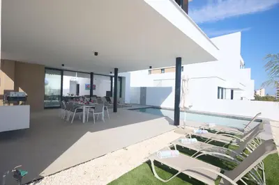 an external view of a house with a pool and chairs at Protaras Aqua Pearl Villa AQ12 in Paralimni