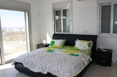 a bedroom with a large bed and a large window at Marymina Villa in Protaras