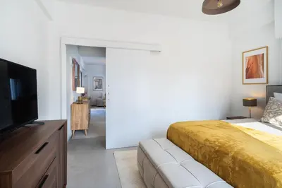 a bedroom with a large bed and a flat screen tv at Elegant City Central Suite in Nicosia