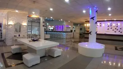 a lobby with a table and stools in a store at Amore Protaras Apartments in Paralimni