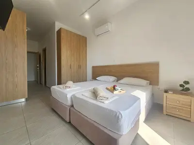 a large bedroom with two beds with white sheets at Piazza Napa Studio Apts self serviced in Ayia Napa