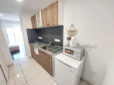 a small kitchen with a sink and a microwave at Piazza Napa Studio Apts self serviced in Ayia Napa