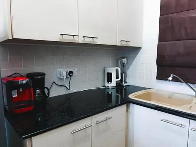 a kitchen with a black counter top and a sink at Déjà Blue Apartment Kyklades BC7 - workspace, pool, gym, nearby beach in Protaras