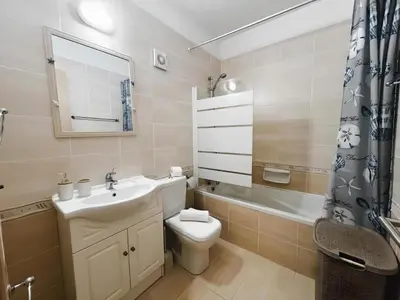 a bathroom with a sink and a toilet and a tub at Déjà Blue Apartment Kyklades BC7 - workspace, pool, gym, nearby beach in Protaras
