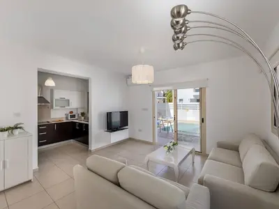 a white living room with a couch and a table at villa Sama palms 21 in Protaras