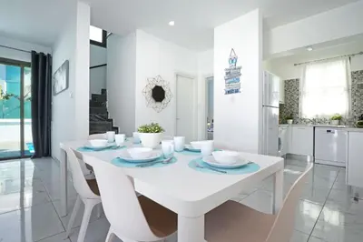 a white dining room with a white table and chairs at Villa Jasmin - 4Bed with Private Pool in Paralimni