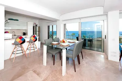 a kitchen and dining room with a table and chairs at Apartment Marisol - Beachfront in Protaras