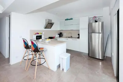 a kitchen with white cabinets and a stainless steel refrigerator at Apartment Marisol - Beachfront in Protaras