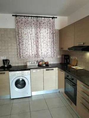 a kitchen with a washing machine and a window at Nissi Area,Ground Floor Flat, Free internet in Ayia Napa