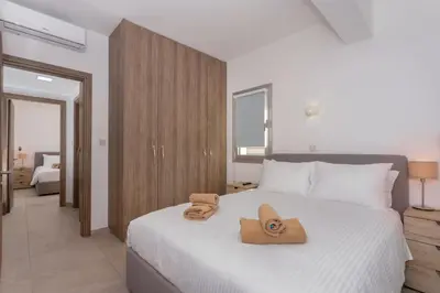 a bedroom with a bed with two slippers on it at City Hall Suites in Limassol