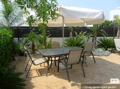 a table and chairs with an umbrella on a patio at Oresti Villa with a pool in Paralimni