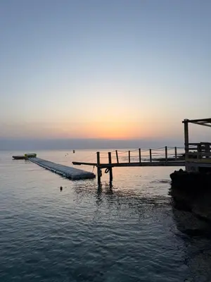 a dock in the water with the sunset in the background at Mythical Sands Resort, Protaras, Choose Joy Apt in Paralimni