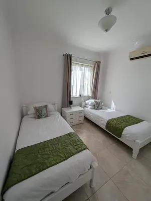 a bedroom with two beds and a window at St Andrews Apartment in Xylophaghou