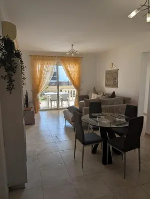 a living room with a table and a couch at St Andrews Apartment in Xylophaghou