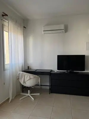 a room with a desk and a chair and a television at Limassol Star Complex Seaview Apartment in Limassol