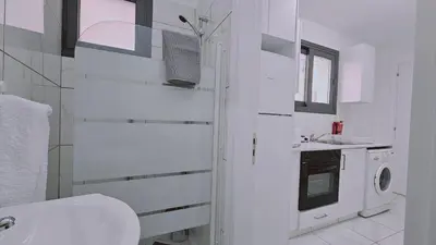 a white bathroom with a sink and a washing machine at STAY Cypress Studio in Limassol