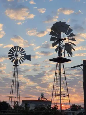 two windmills against a cloudy sky at sunset at Little Paradise in Sotira