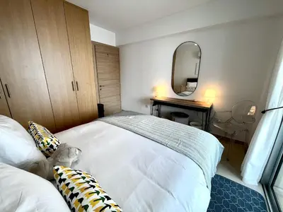 a bedroom with a white bed and a mirror at STAY Chromata Lagoon Apartment in Protaras