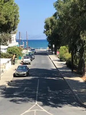 a street with cars parked on the side of the road at Atlantis Court in Makenzy in Larnaka