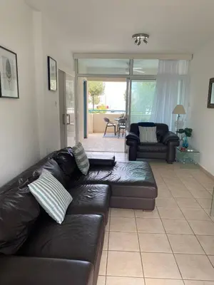a living room with a black leather couch at Atlantis Court in Makenzy in Larnaka
