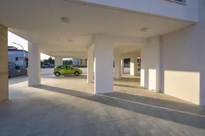 a green car is parked in a parking lot at Mulberry Court Premium Apartments in Limassol