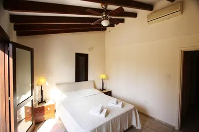 a bedroom with a bed and a ceiling fan at The Bay Villa in Pissouri