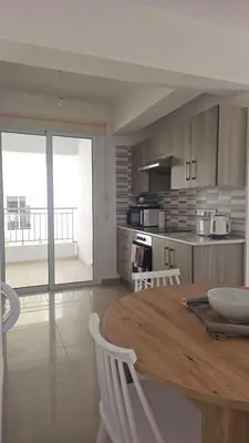 a kitchen with a wooden table and white chairs at Obv 3206 in Pyla