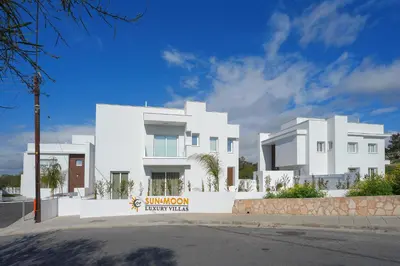 a white building with a sign in front of it at Sun and Moon Luxury Villas Ayia Napa in Ayia Napa