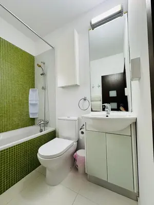 a bathroom with a white toilet and a sink at Villa Eva in Mazotos