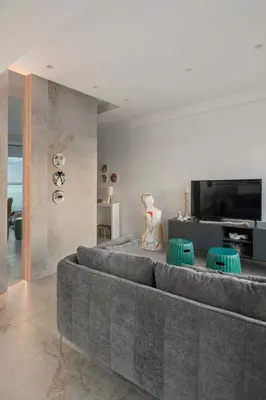 a living room with a couch and a flat screen tv at Luxury Beachfront Apartment in Limassol