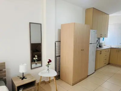 a kitchen with a refrigerator and a table with a vase of flowers at Marielenas in Larnaka