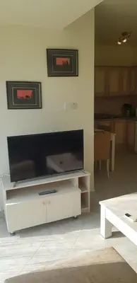 a living room with a large flat screen tv on a wall at Beautiful 1-Bed House in Aglantzia