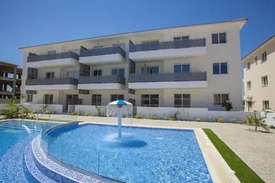 a building with a swimming pool in front of a building at Mythical Sands - Saltos in Paralimni