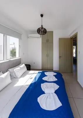 a bedroom with a large bed with three pillows on it at Nissini Villas in Ayia Napa