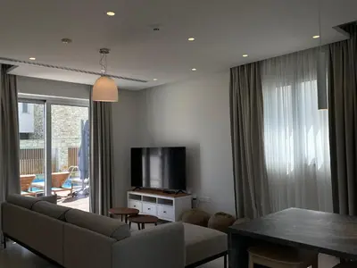 a living room with a couch and a television at City Napa Seaview Villas - Villa 2 in Ayia Napa