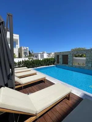 a swimming pool with chaise lounges next to a building at City Napa Seaview Villas - Villa 2 in Ayia Napa