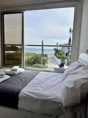 a bedroom with a large window with a view of the ocean at Luxury Villa Azure in Larnaka