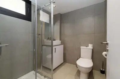 a bathroom with a toilet and a glass shower at Finikoudes Marina View 202 in Larnaka