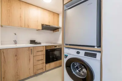 a washer and dryer in a kitchen with a refrigerator at Finikoudes Marina View 202 in Larnaka