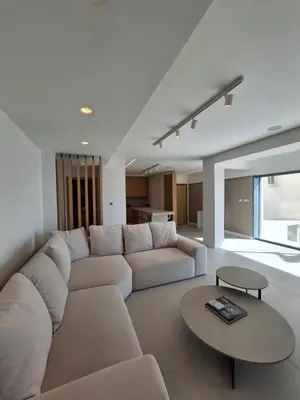a living room with a white couch and a table at Deluxe Seafront - 2 Bed in Limassol