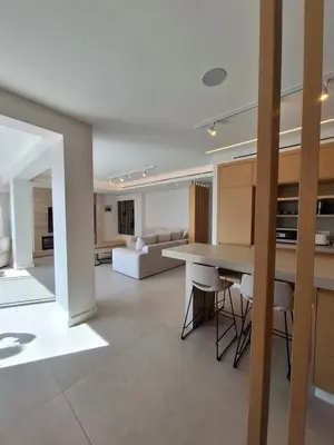 a kitchen and living room with a table and chairs at Deluxe Seafront - 2 Bed in Limassol