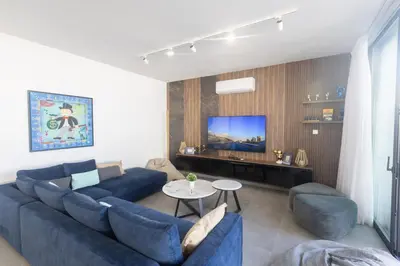 a living room with a blue couch and a tv at Protaras Aqua Pearl Villa AQ18 in Protaras