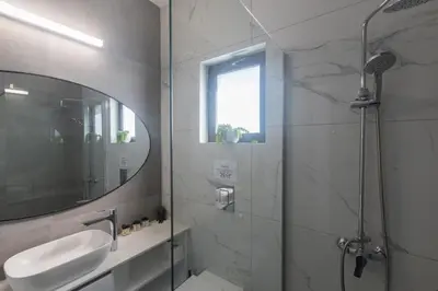 a bathroom with a shower and a sink and a mirror at Protaras Aqua Pearl Villa AQ18 in Protaras